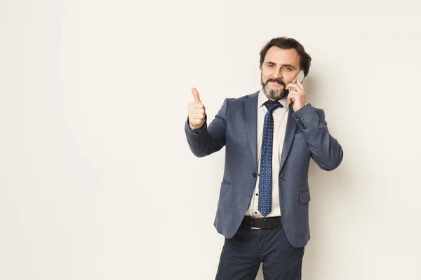 Cheerful bearded businessman talking on phone — Stock Photo, Image