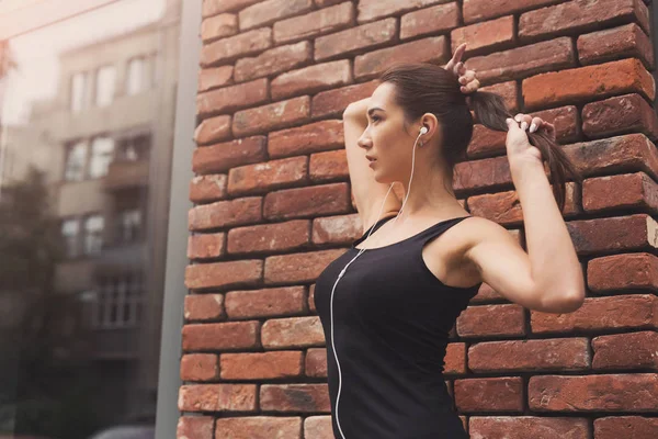 Hermosa chica de fitness posando sobre fondo de pared de ladrillo — Foto de Stock