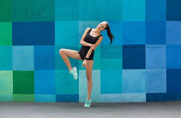 Hermosa chica de fitness posando sobre fondo azul — Foto de Stock