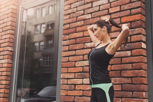 Nádherné fitness dívka pózuje na cihlovou zeď na pozadí — Stock fotografie