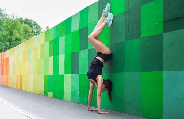 Young woman doing handstand on city street — Stock Photo, Image