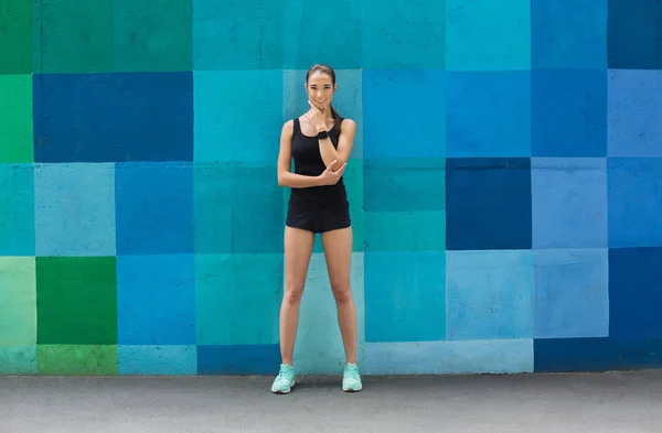 Фитнес-девушка, позирующая на синем фоне — стоковое фото