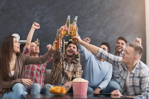 Group of young friends with bottles of drink at home — Stock Photo, Image