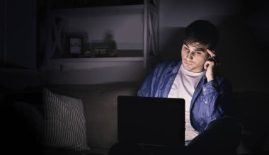 Dalgın adam geç saate kadar evde üstünde laptop