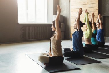 Genç kadın ve erkek yoga sınıfındaki rahatla meditasyon poz