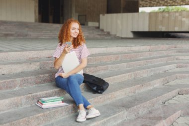 Açık havada Smartphone kullanan mutlu genç kadın