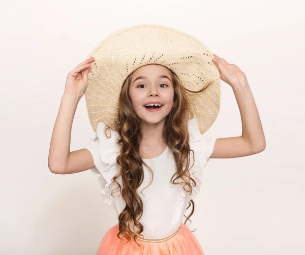 Портрет маленької дівчинки в солом'яному капелюсі на білому тлі — стокове фото