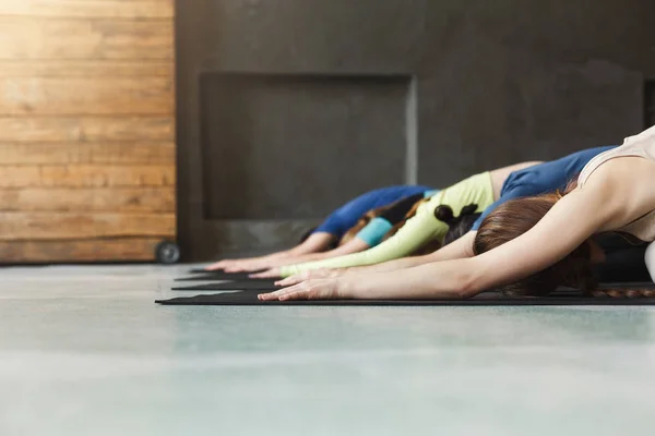 Mladé ženy a muži v třídě jógy, relaxujte meditační pozice — Stock fotografie