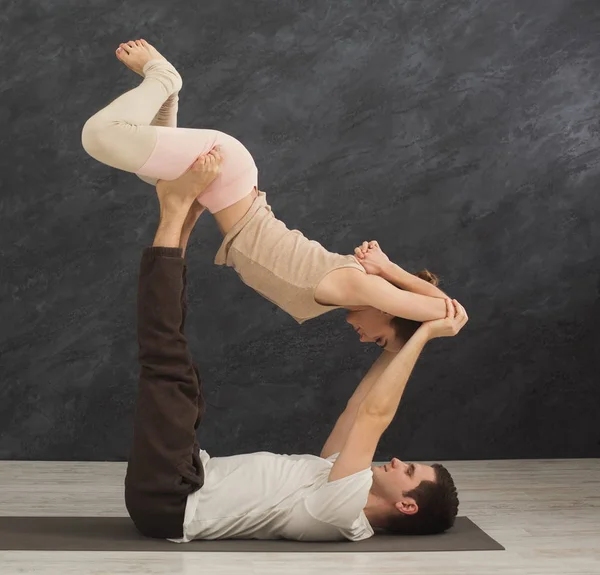 Jong koppel samen met het beoefenen van acroyoga op mat — Stockfoto