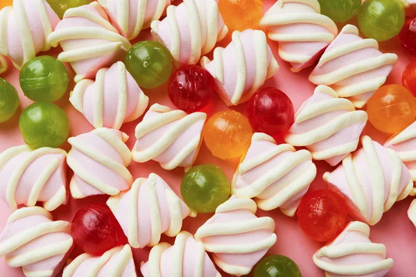 Σωρού marshmallows και πολύχρωμα γλυκά σε ροζ φόντο — Φωτογραφία Αρχείου