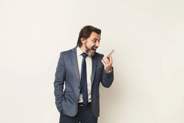 Wütender Geschäftsmann weint am Telefon vor weißem Hintergrund — Stockfoto