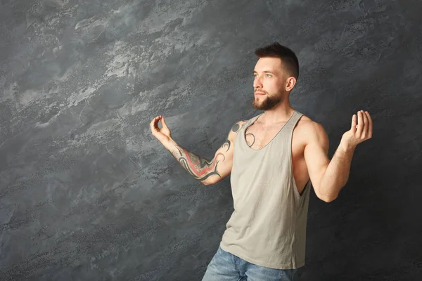 Gelukkig knap man maken een yoga pose in studio — Stockfoto