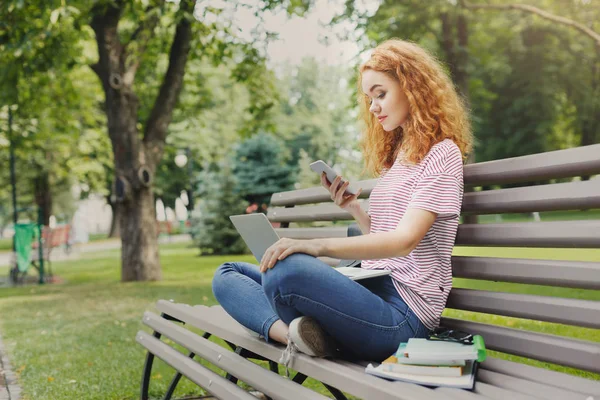 Student SMS na smartphone v parku — Stock fotografie