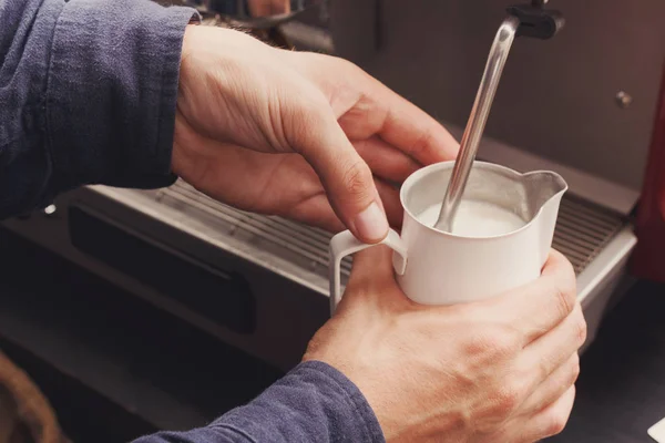 Closeup of barmen hand steaming milk in cafe — Stock Photo, Image