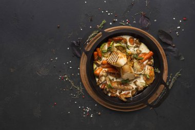 Siyah arka plan üzerine tencerede tavuk ve sebze komposto