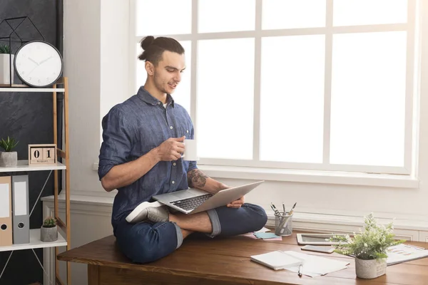 Hombre flexible practicando yoga en el lugar de trabajo — Foto de Stock