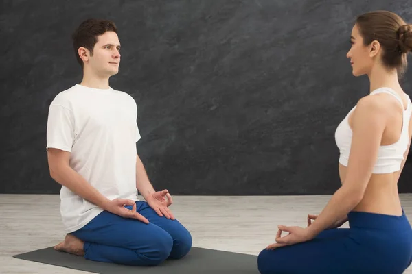 Young couple meditating together, opposite each other — Stock Photo, Image