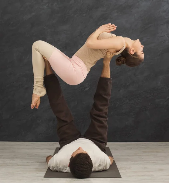 若いカップルが一緒にマットで acroyoga の練習 — ストック写真