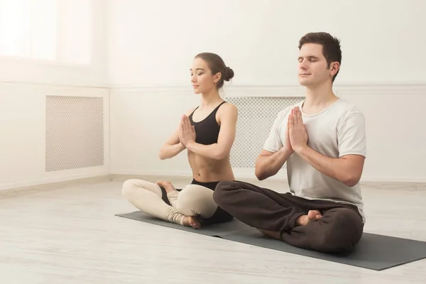 Ungt par öva yoga sitter i padmasana — Stockfoto
