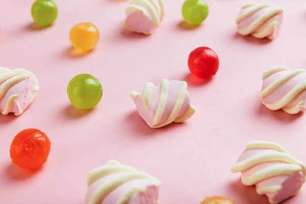 Closeup of marshmallows and colourful sweets on pink background — Stock Photo, Image