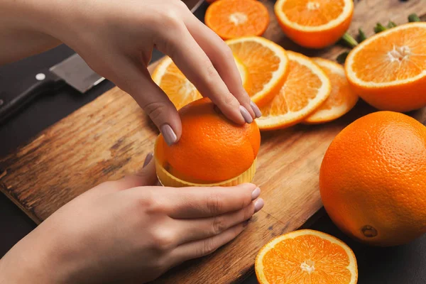 Mãos femininas fazendo suco de laranja, close-up — Fotografia de Stock