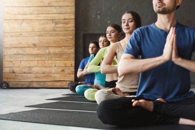 Genç kadın ve erkek yoga sınıfındaki rahatla meditasyon poz