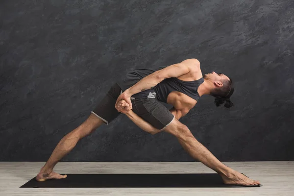 Hombre estirando las manos y las piernas en el gimnasio — Foto de Stock