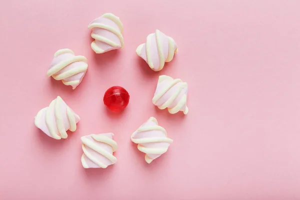 Зефир и красные конфеты на розовом фоне — стоковое фото