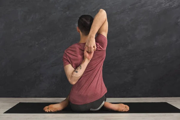 Hombre entrenamiento yoga en vaca cabeza pose — Foto de Stock