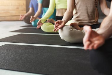 Genç kadın ve erkek yoga sınıfındaki rahatla meditasyon poz