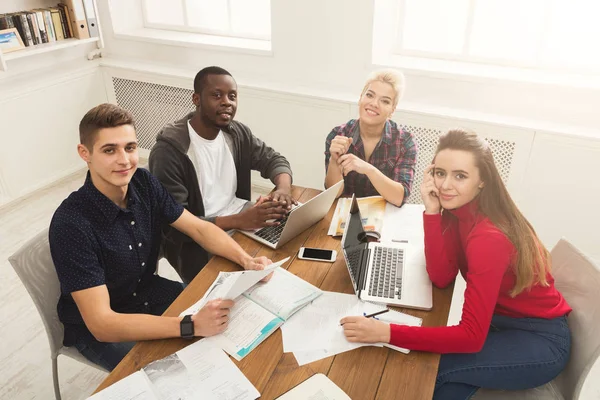 Gruppo di studenti diversi che studiano al tavolo di legno — Foto Stock