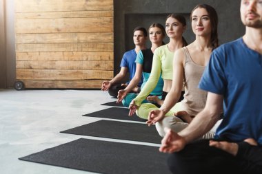 Genç kadın ve erkek yoga sınıfındaki rahatla meditasyon poz
