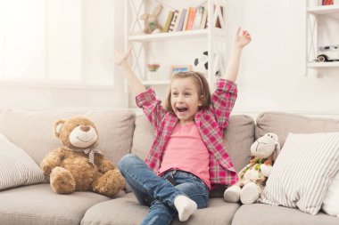 Küçük kız kanepede otururken TV izlerken