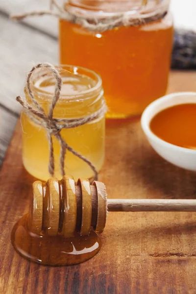 Med, sklenice a dřevěná naběračka, closeup — Stock fotografie
