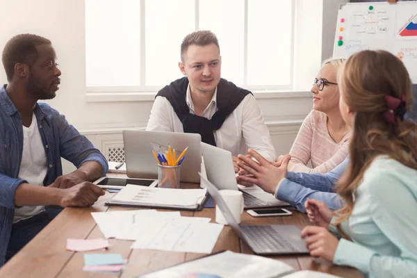 Equipo joven discutiendo proyecto en oficina moderna — Foto de Stock