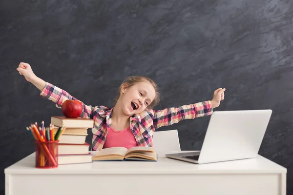 Menina bonito alongamento ao fazer lição de casa no laptop — Fotografia de Stock