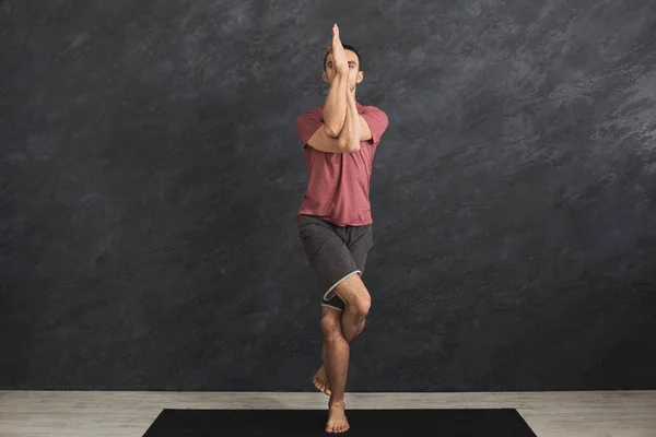 Joven hombre flexible practicando yoga en el gimnasio — Foto de Stock