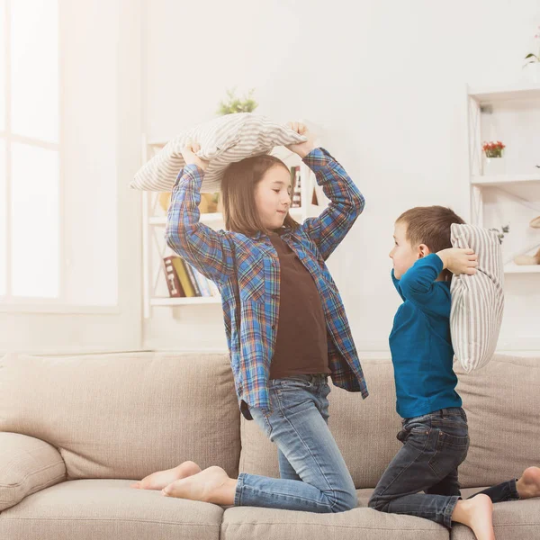 Bruder und Schwester bei Kissenschlacht auf Sofa — Stockfoto