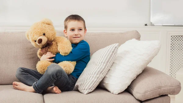 Pequeño niño lindo con oso de peluche en la sala de estar —  Fotos de Stock