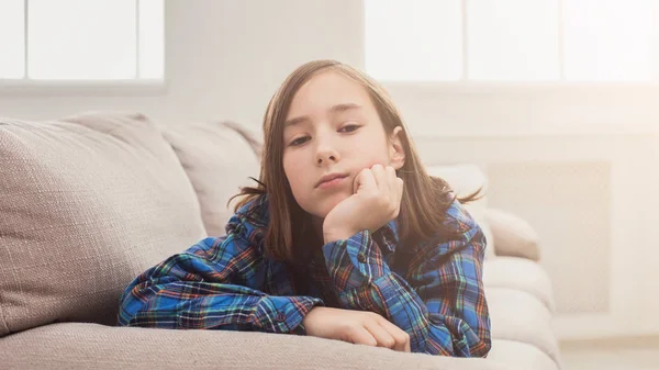 Tired girl sitting on sofa at home — Stock Photo, Image