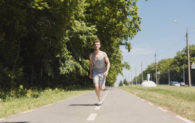 Genç adam Park, kopya alanı treadmill koşu