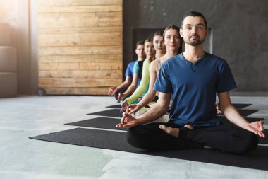 Genç kadın ve erkek yoga sınıfındaki rahatla meditasyon poz
