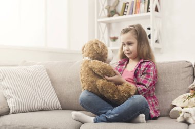 Mutlu küçük oyuncak ayısının kanepede sarılma