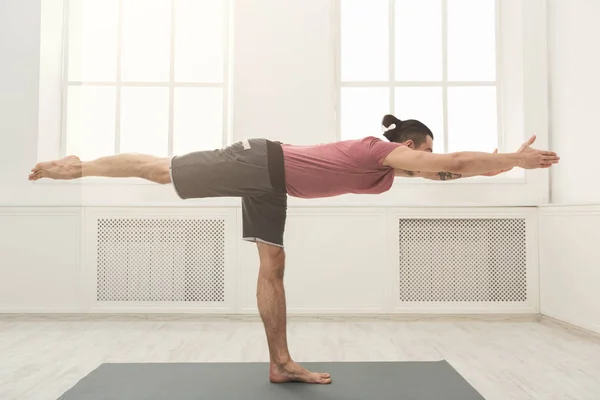 Hombre estirando las manos y las piernas en el gimnasio — Foto de Stock