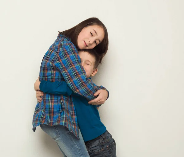 Feliz hermano y hermana abrazo, fondo del estudio — Foto de Stock