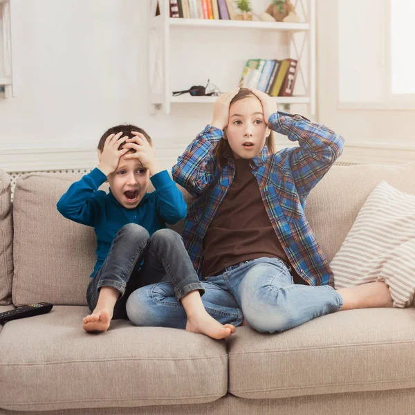 Frightened children watching TV at home