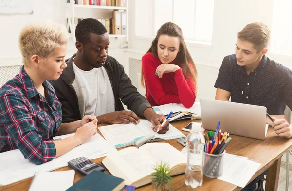 Gruppe verschiedener Studenten, die am Holztisch lernen — Stockfoto