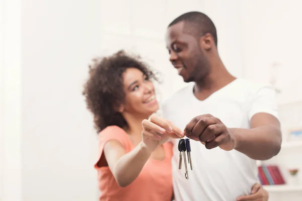 Happy black couple holding keys of their new home