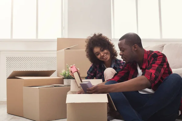 Jovem casal balck desempacotar caixas móveis — Fotografia de Stock