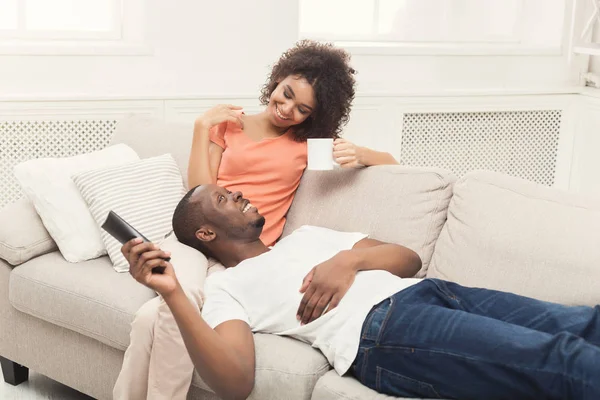 Felice coppia afro-americana guardando la TV a casa — Foto Stock